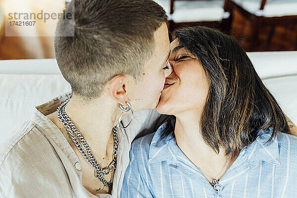 Junges lesbisches Paar küsst sich zu Hause