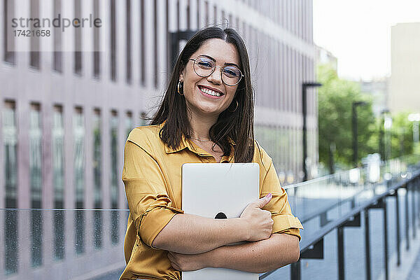 Lächelnde Geschäftsfrau mit Laptop im Büropark