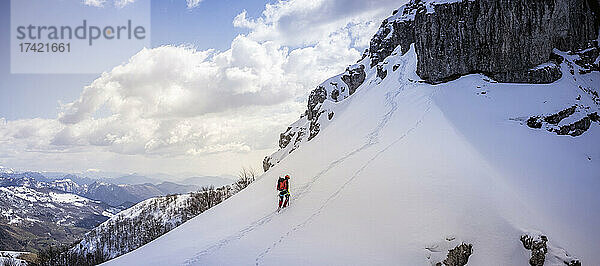 Reifer Mann beim Wandern auf einem schneebedeckten Berg  Bergamasker Alpen  Lecco  Italien
