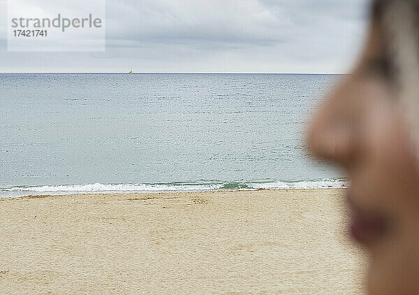 Frau blickt auf den Strand