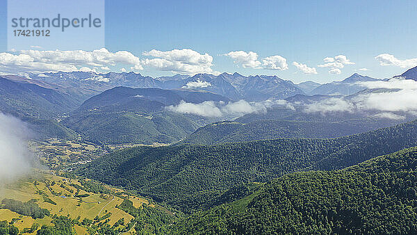 Malerische Aussicht auf niedrige Wolken  die über den grünen bewaldeten Pyrenäen schweben