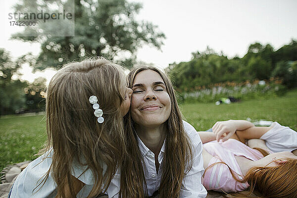 Mädchen küsst Mutter im öffentlichen Park