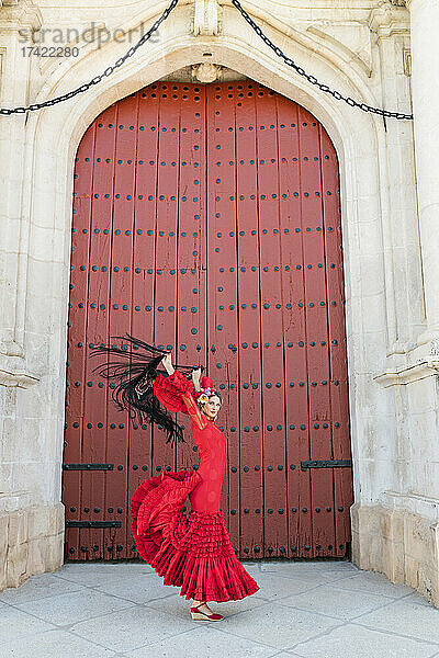 Flamenco-Künstlerin tanzt mit erhobenen Händen auf dem Fußweg