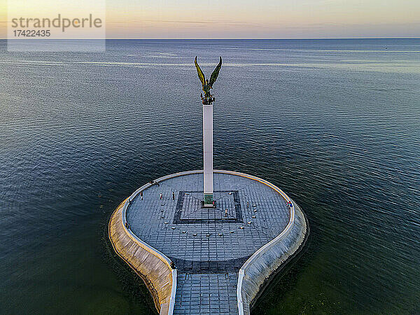 Mexiko  Campeche  San Francisco de Campeche  Luftaufnahme der Engel-Maya-Statue auf der Plaza del Mar in der Abenddämmerung mit klarer Horizontlinie über dem Meer im Hintergrund