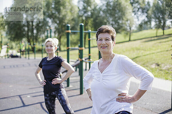 Frauen mit der Hand auf der Hüfte trainieren im Park