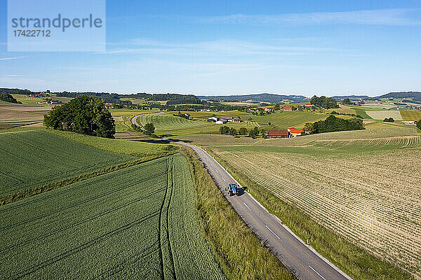 Österreich  Oberösterreich  Waldzell  Drohnenansicht einer Landstraße  die sich im Sommer zwischen Feldern erstreckt