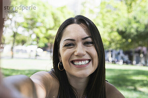 Lächelnde schöne Frau  die Selfie im öffentlichen Park macht