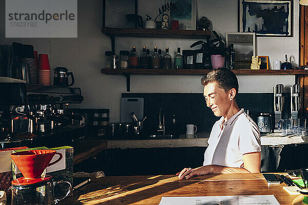 Lächelnde Barista im Café an sonnigen Tagen