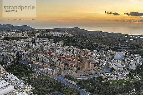 Malta  Nordregion  Mellieha  Luftaufnahme der Küstenstadt in der Abenddämmerung mit der Pfarrkirche der Geburt der Jungfrau Maria in der Mitte