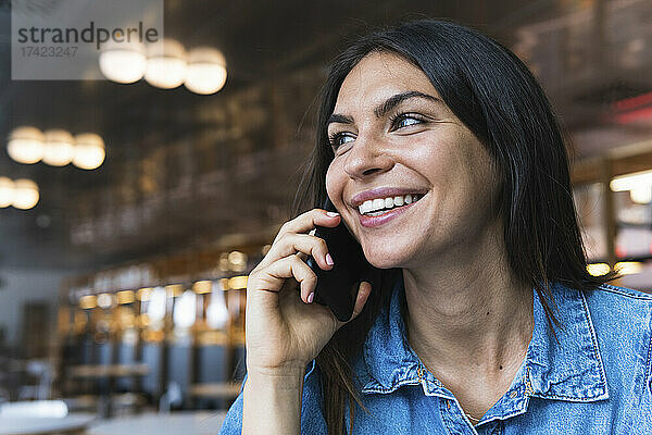 Schöne Freiberuflerin  die im Café mit dem Handy spricht