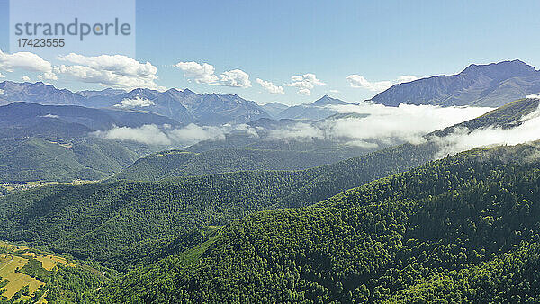 Malerische Aussicht auf niedrige Wolken  die über den grünen bewaldeten Pyrenäen schweben