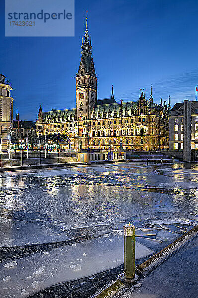 Deutschland  Hamburg  Eis schwimmt in der Abenddämmerung im Stadtkanal  im Hintergrund das Hamburger Rathaus