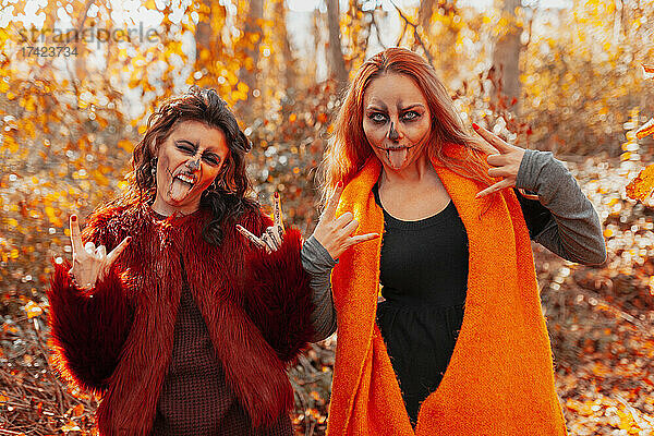 Verspielte Freunde strecken im Herbst im Wald die Zunge heraus
