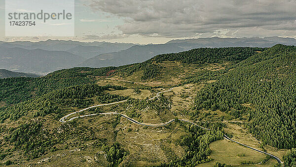 Luftaufnahme einer Landstraße  die sich durch die bewaldete Landschaft der Pyrenäen erstreckt