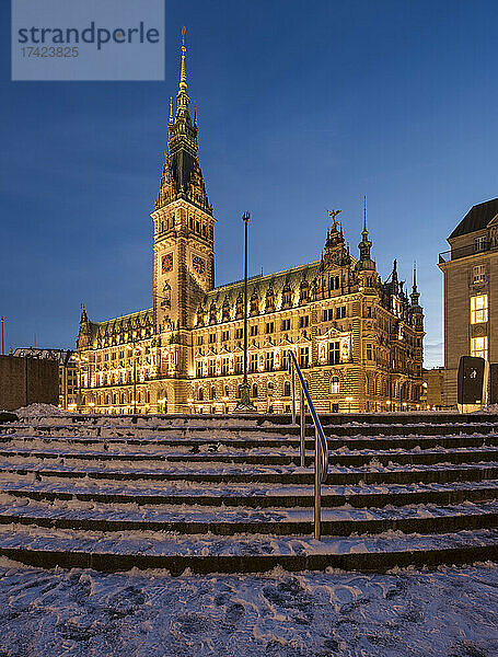 Deutschland  Hamburg  Verschneite Stufen vor dem beleuchteten Hamburger Rathaus in der Abenddämmerung