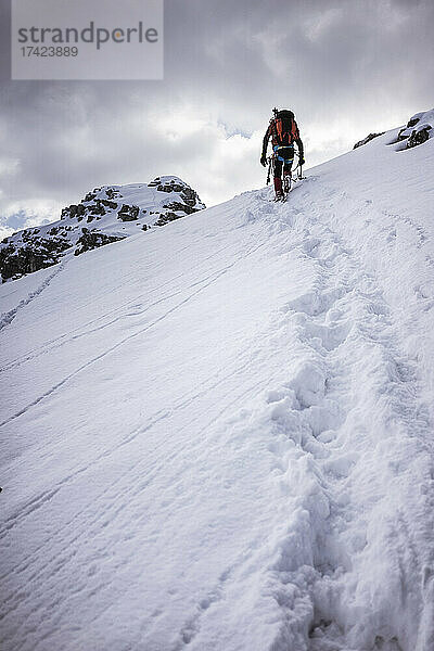 Männlicher Wanderer auf schneebedecktem Berg in den Bergamasker Alpen  Lecco  Italien
