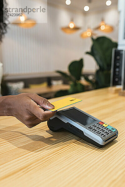 Geschäftsfrau zahlt im Café per Kreditkarte