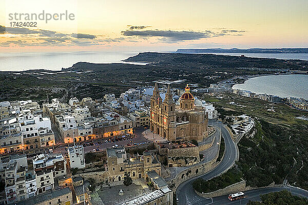 Malta  Nordregion  Mellieha  Luftaufnahme der Küstenstadt in der Abenddämmerung mit der Pfarrkirche der Geburt der Jungfrau Maria in der Mitte