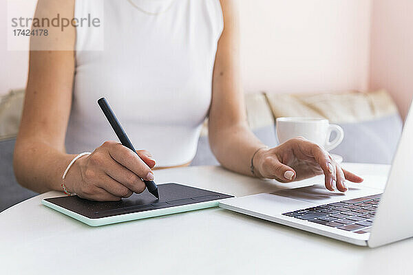 Weibliche Designprofis mit Laptop und Grafiktablett im Café