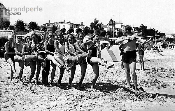 Gruppe mit Badenden am Strand  witzig  lachen  Sommerferien  Ferien  Lebensfreude  hoch das Bein  etwa 1930er Jahre  Ostsee  Binz  Rügen  Mecklenburg-Vorpommern  Deutschland  Europa
