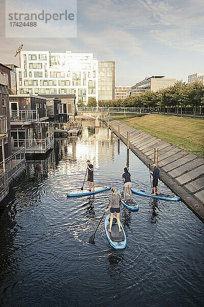 Hohe Winkel Ansicht der männlichen und weiblichen Freunde Paddleboarding im Meer