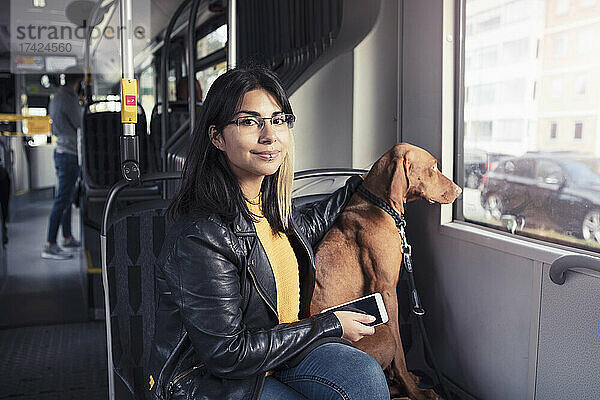 Porträt einer jungen Frau  die mit ihrem Hund in einer Seilbahn sitzt