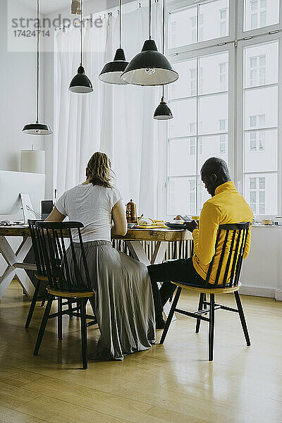 Mittlerer erwachsener Mann und Frau beim gemeinsamen Frühstück zu Hause