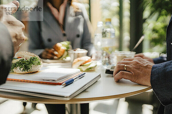 Geschäftsfrau mit Geschäftsmann am Tisch stehend beim Essen während einer Netzwerkveranstaltung im Kongresszentrum