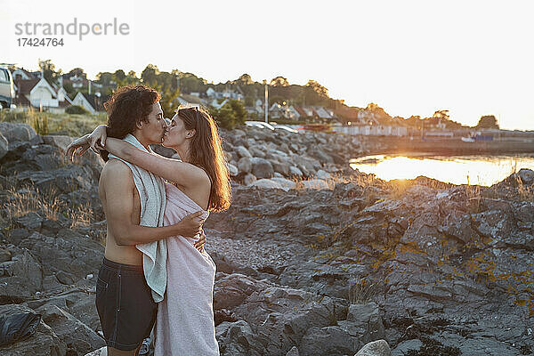 Freundin und Freund küssen sich  während sie auf einem Felsen stehen