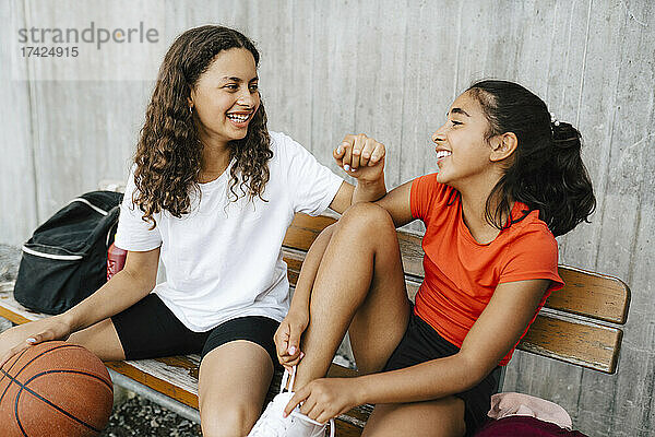 Glückliche Mädchen verbringen ihre Freizeit auf dem Basketballplatz