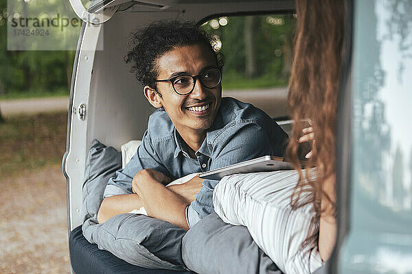 Lächelnder Mann schaut seine Freundin im Campingwagen an