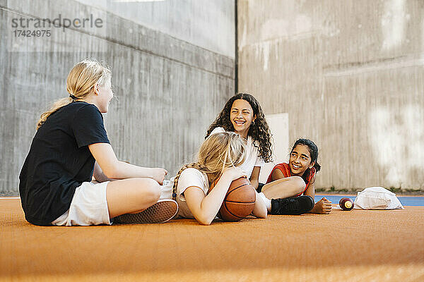 Vorpubertäre Mädchen unterhalten sich in ihrer Freizeit auf dem Sportplatz