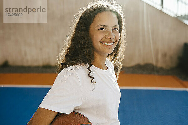 Porträt eines glücklichen vorpubertären Mädchens auf dem Sportplatz