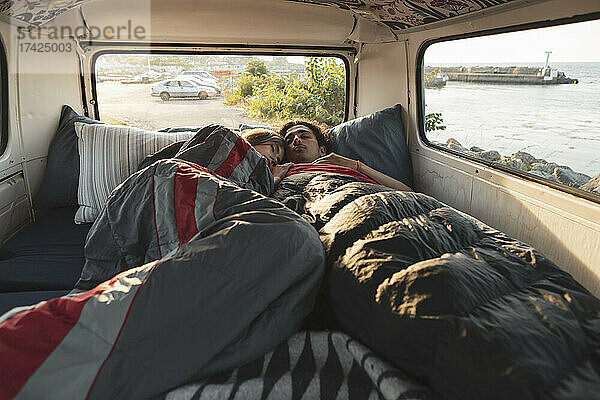 Junges Paar ruht sich im Campingwagen am Meer aus