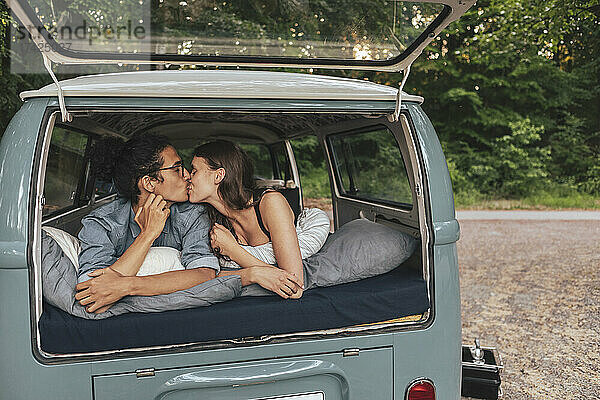 Freundin und Freund küssen sich im Van