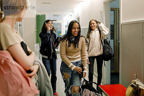 Glückliche Teenager-Mädchen im Schulkorridor