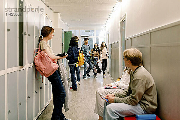 Mädchen und Jungen im beleuchteten Schulkorridor