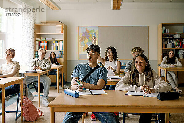 Mädchen und Jungen beim Lernen am Schreibtisch im Klassenzimmer