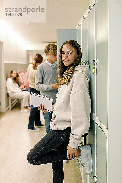 Porträt eines Teenagers vor einem Spind in der Schule