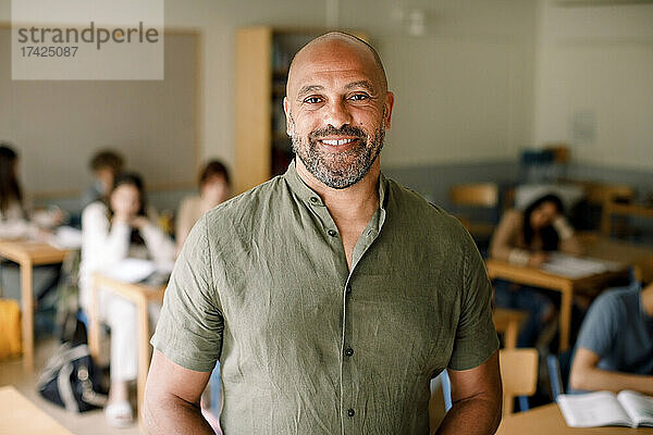 Porträt eines lächelnden männlichen Professors im Klassenzimmer