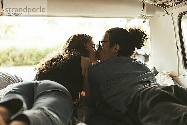 Junges Paar küsst sich im Campingbus