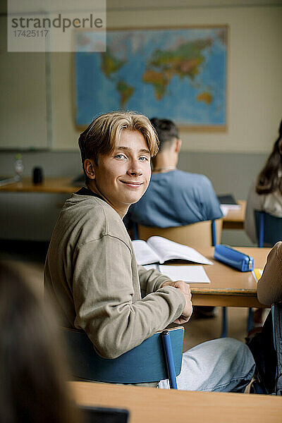 Porträt eines Teenagers  der auf einem Stuhl im Klassenzimmer sitzt