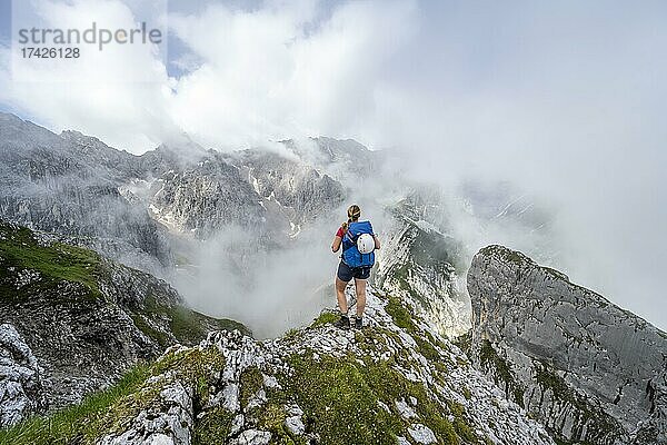 Wanderin blickt auf Berge bei dramatischen Wolken  Wettersteingebirge  Garmisch-Partenkirchen  Bayern  Deutschland  Europa