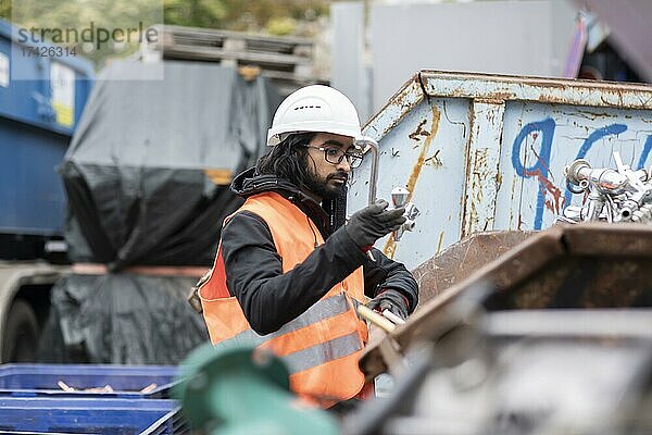 Techniker mit Bart und Helm arbeitet in einem Recylingplatz  Freiburg  Baden-Württemberg  Deutschland  Europa