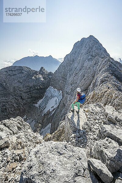 Wanderin an einer Felskante  hinten Hochkalter und Blaueis Gletscher  Wanderung zum Hochkalter  Berchtesgadener Alpen  Berchtesgadener Land  Oberbayern  Bayern  Deutschland  Europa