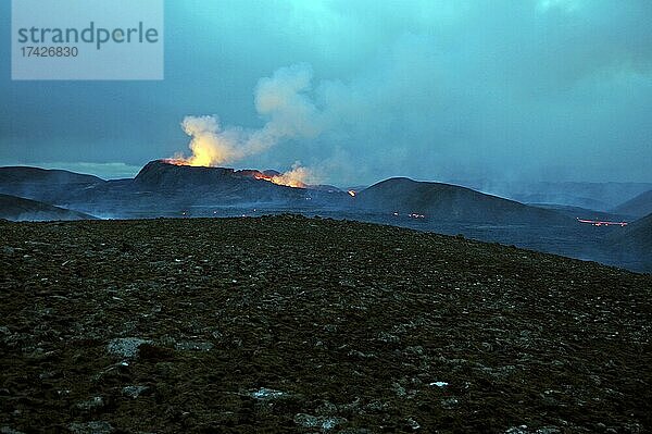 Steinwüste und aktiver Vulkan im Hintergrund  Glühende Lavafontänen  Fagradalsfjall  Reykjanes  Grindavik  Sudurnes  Island  Europa