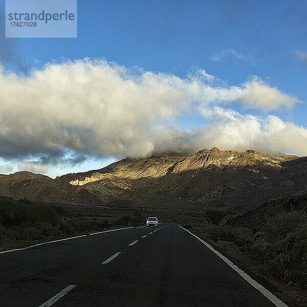 Pkw fährt auf Straße TF-24 durch vulkanische Landschaft  nahe Vulkan Pico del Teide  Abendlicht  Nationalpark Teide  Teneriffa  Spanien  Europa