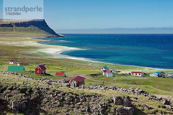 Einzelne Häuser an einer weiten Bucht  karge Berge und Strand  Latrabjarg  Vestfirðir  Westfjorde  Island  Europa