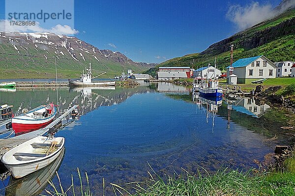 Kleine Fischerboote spiegeln sich im Hafenbecken  Berge und Schnee  Seydisfjördur  Ostisland  Island  Europa