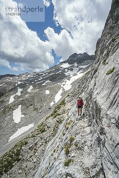 Wanderin an einer Felswand  Klettersteig zur Patenkirchner Dreitorspitze  Wettersteingebirge  Garmisch-Partenkirchen  Bayern  Deutschland  Europa
